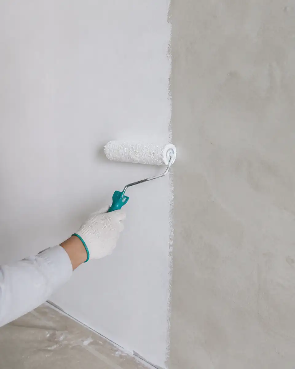 Lăn sơn lót màu trắng trên bề mặt tường đã chuẩn bị